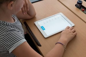 Symbolbild: Speech - Digitalization: Schüler*in mit iPad im Unterricht